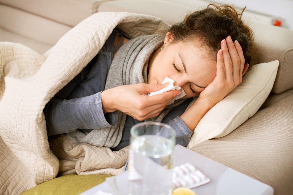 Sick Woman. Flu. Woman Caught Cold. Sneezing into Tissue